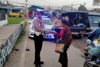Personil Satlantas Polres Ende sedang membagikan masker kepada seorang Ibu di Pasar Mbongawani
