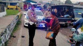 Personil Satlantas Polres Ende sedang membagikan masker kepada seorang Ibu di Pasar Mbongawani