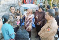 Mentri Mendukngga/Kepala BKKBN RI, Dr. Wihaji sedang menggendong anak dari keluarga berisiko stunting, Jeni Humsibu di Kelurahan Sikumana, Kota Kupang (Foto: AR)