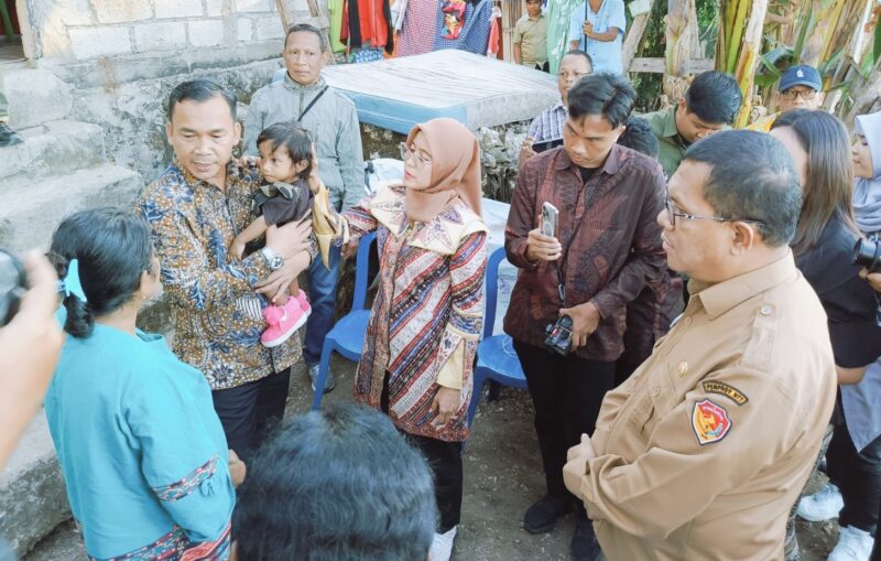 Mentri Mendukngga/Kepala BKKBN RI, Dr. Wihaji sedang menggendong anak dari keluarga berisiko stunting, Jeni Humsibu di Kelurahan Sikumana, Kota Kupang (Foto: AR)