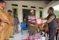 Kepala Bidang Perlindungan dan Jaminan Sosial, Dikson Amtiran menyerahkan bantuan ke keluarga korban