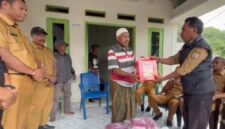 Kepala Bidang Perlindungan dan Jaminan Sosial, Dikson Amtiran menyerahkan bantuan ke keluarga korban