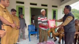 Kepala Bidang Perlindungan dan Jaminan Sosial, Dikson Amtiran menyerahkan bantuan ke keluarga korban