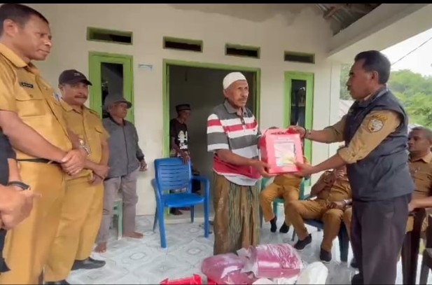 Kepala Bidang Perlindungan dan Jaminan Sosial, Dikson Amtiran menyerahkan bantuan ke keluarga korban